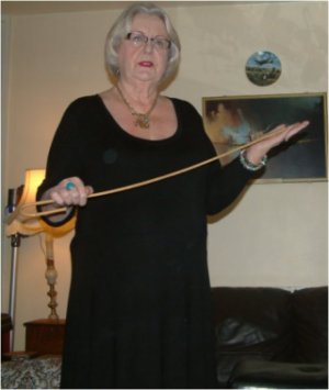 A photo of Mistress Susanne standing holding a cane